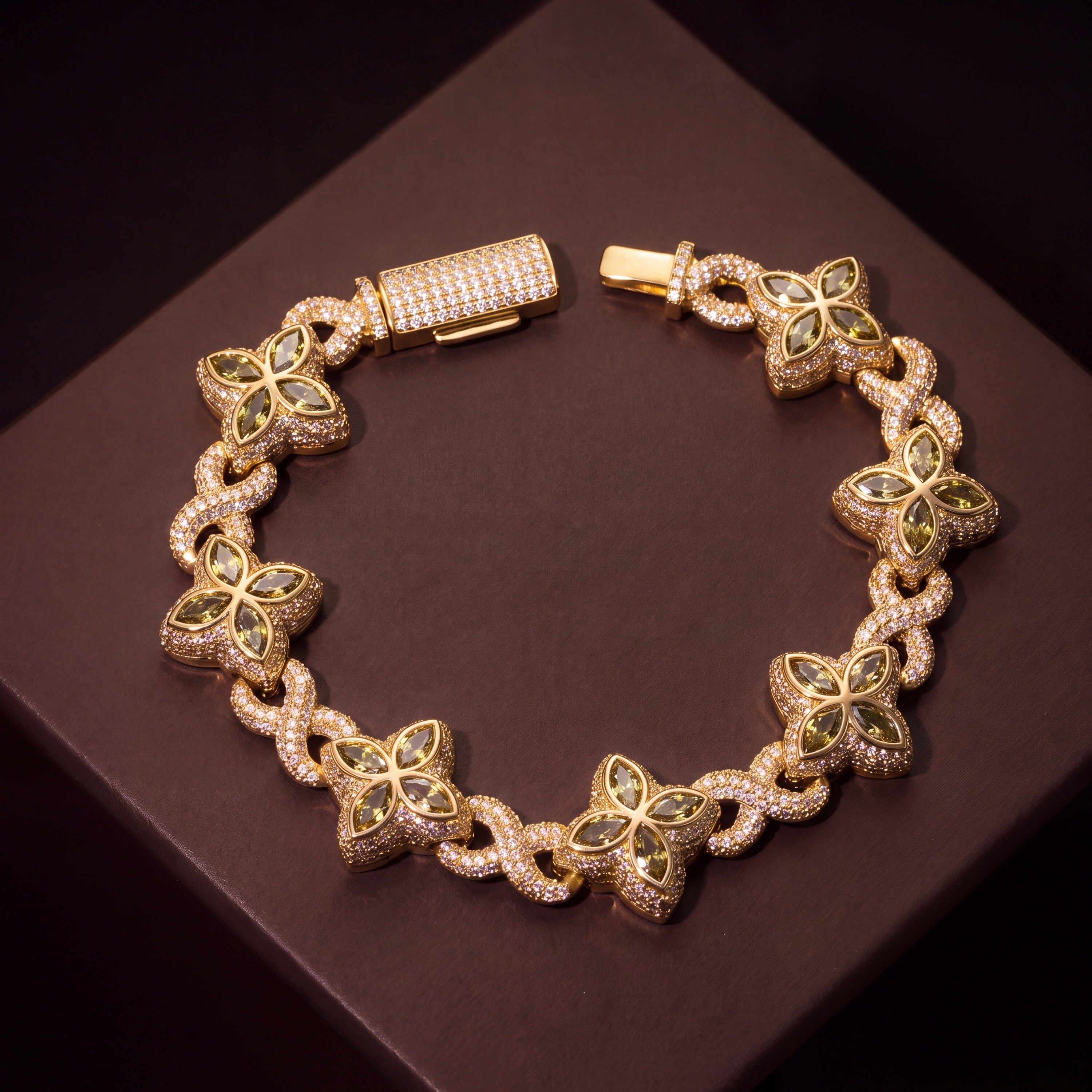 Gold-tone clover flower bracelet laid flat, olive-green petals on pave infinity links